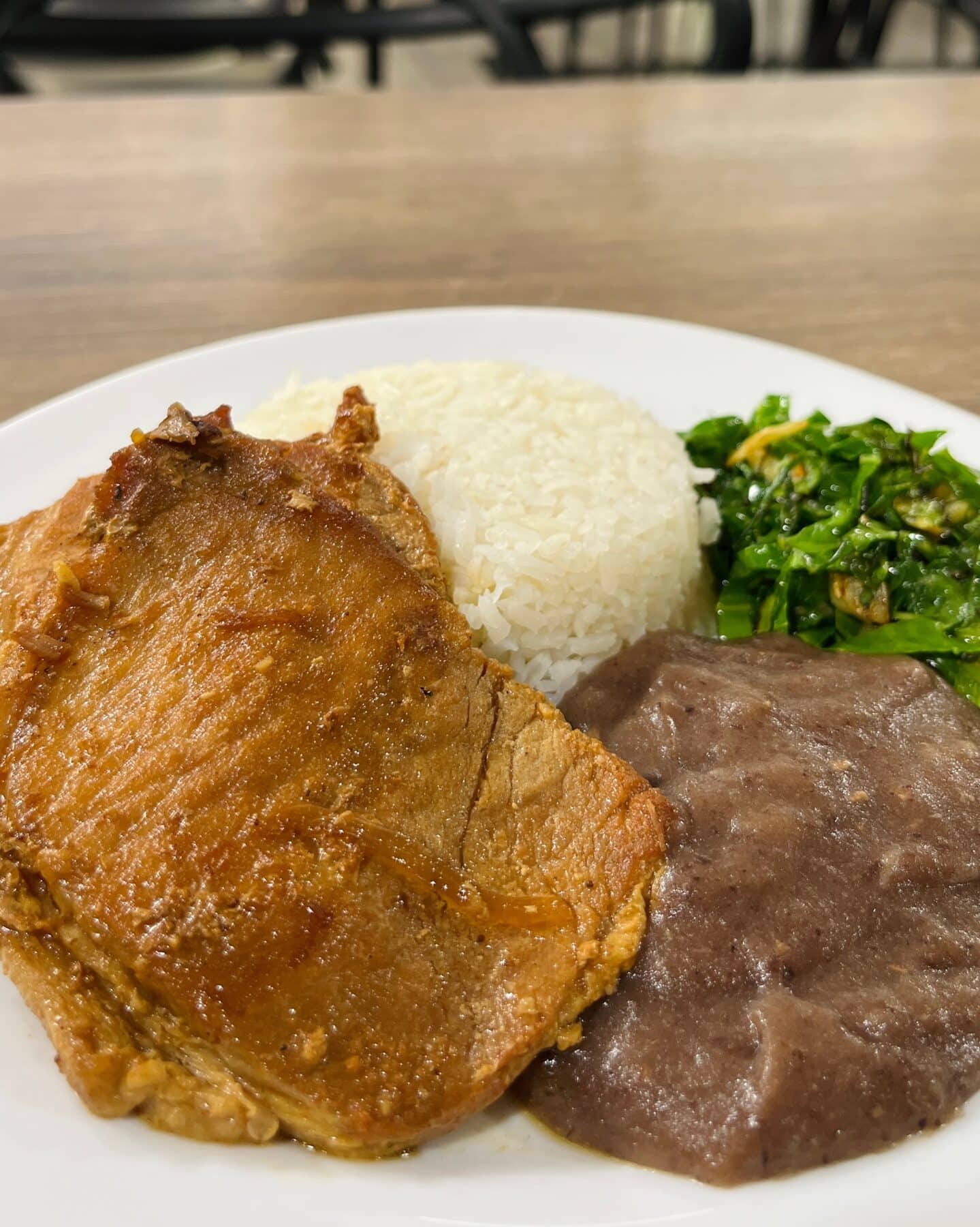 Carré suíno grelhado servido com arroz, couve refogada e feijão