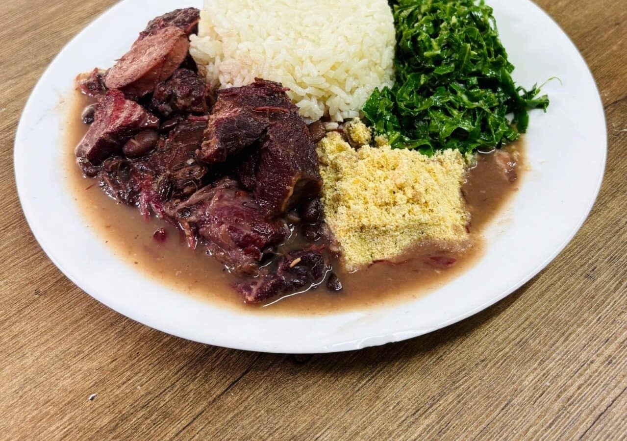 Prato de feijoada com arroz, couve refogada e farofa