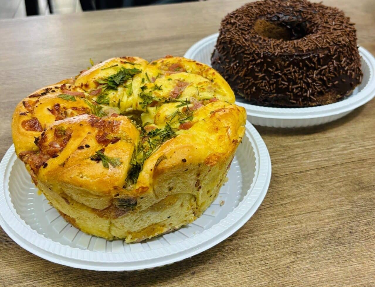 Torta salgada e bolo de chocolate com granulado servidos lado a lado em pratos de louça